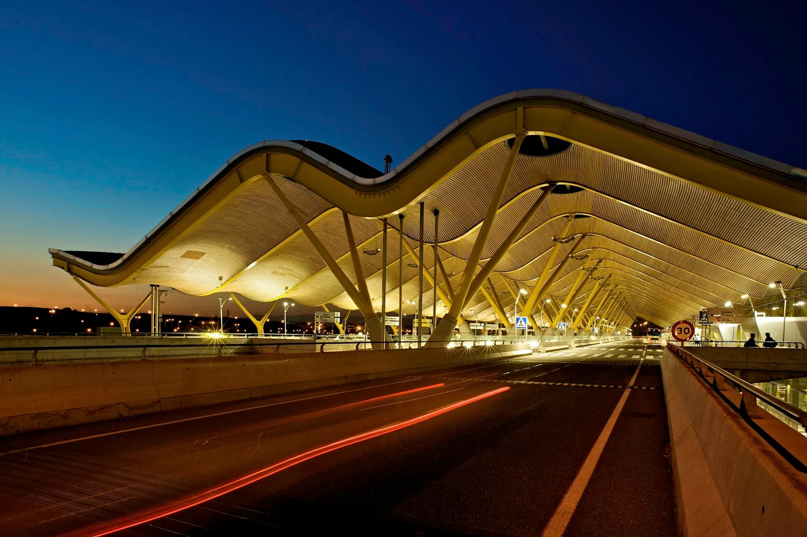 Fachada del Aeropuerto de Madrid-Barajas Adolfo Suárez de noche, en el Distrito de Barajas, Madrid, destacando su conexión con la renta y alquiler de propiedades. youhomey.