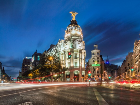 Vista nocturna del Edificio Metrópolis en el centro de Madrid, representando el núcleo urbano y el alto coste de vida que impulsa la inversión inmobiliaria hacia las zonas rurales cercanas en busca de mayor rentabilidad.