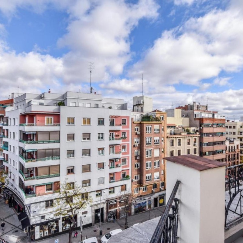 Vista desde un balcón de varios edificios de apartamentos residenciales típicos del barrio de Embajadores, mostrando el potencial de inversión inmobiliaria en la zona.